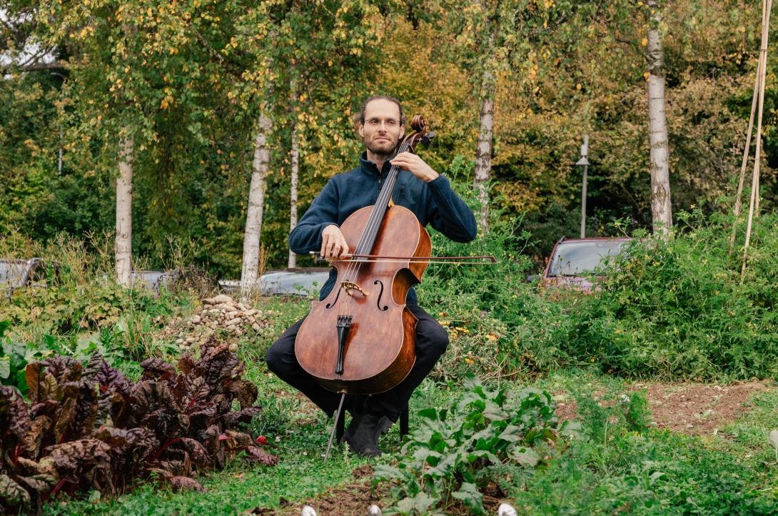 Cellist spielt im Gemeinschaftsgarten